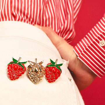 Raspberry clip jewel worn on a white jeans buttock pocket and red striped blouse